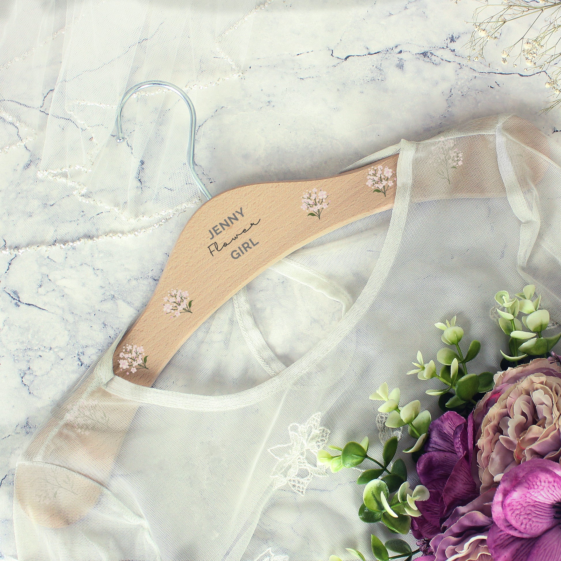 PERSONALISED wooden wedding hanger with three lines of text and flowers along the arms of the hanger