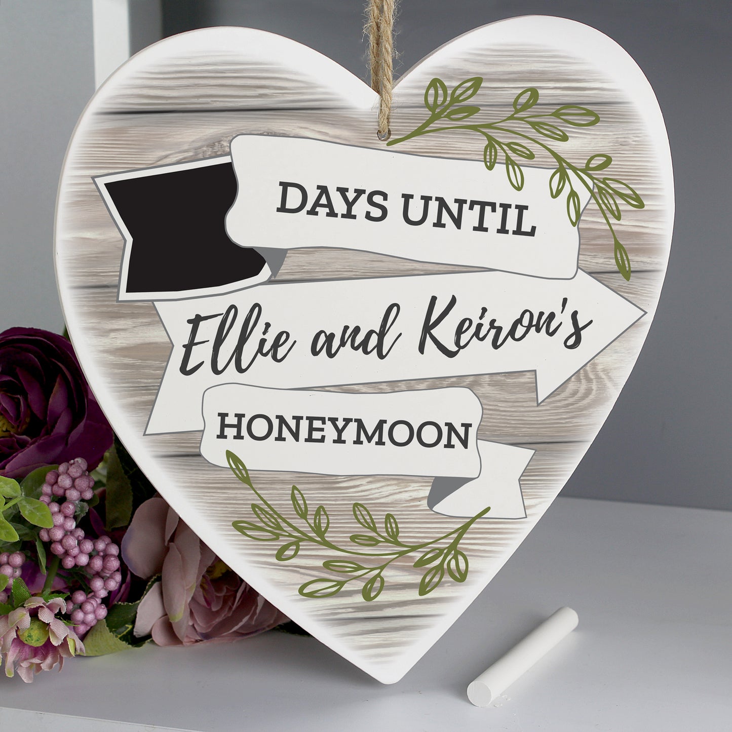 A wooden heart adorned with a wood and leaf finish and a small incorporated chalkboard for you to count down the days to your wedding. Personalised with the names of the happy couple.