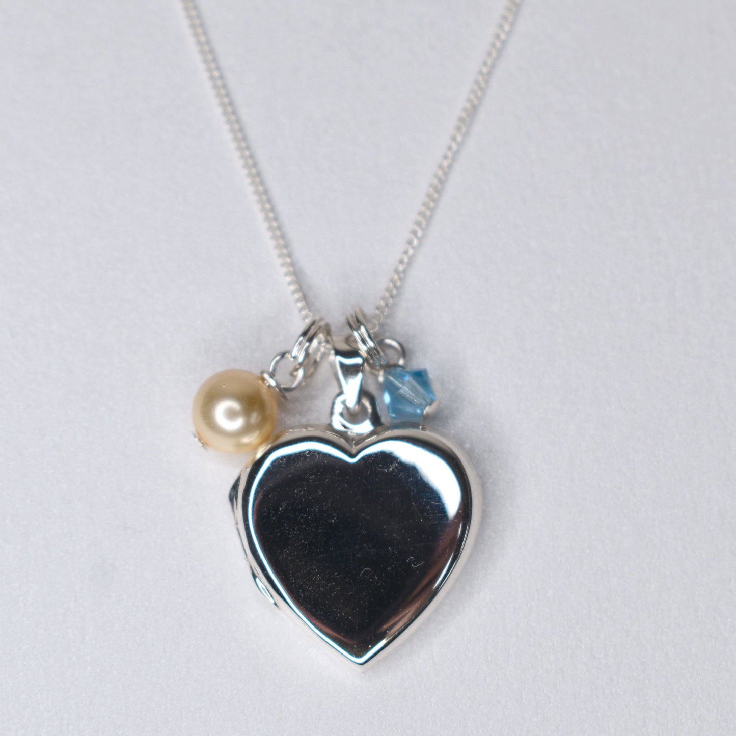 Sterling silver heart locket with cream pearl and blue crystal