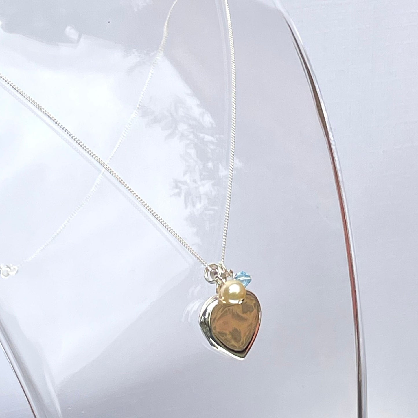 Sterling silver heart locket with cream pearl and blue crystal