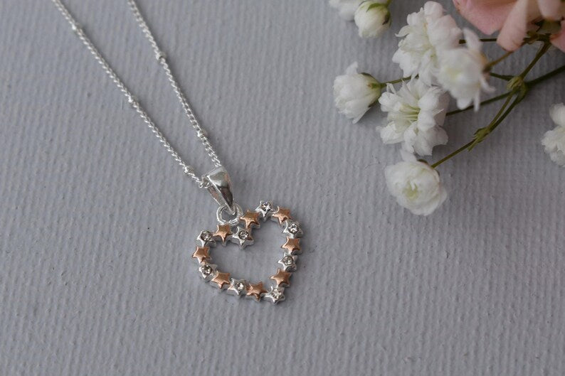 Heart of Stars heart-shaped pendant, designed with interconnecting stars and tiny cubic zirconias set in every other star. Available in all silver or silver and rose gold.