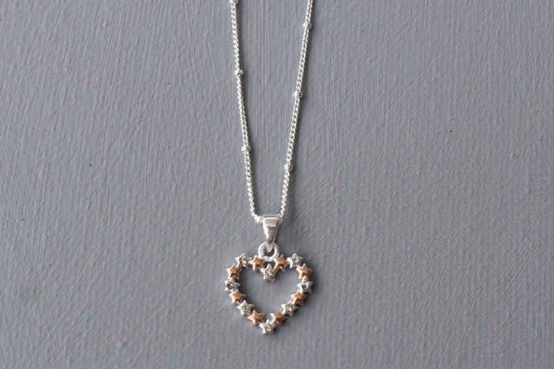 Heart of Stars heart-shaped pendant, designed with interconnecting stars and tiny cubic zirconias set in every other star. Available in all silver or silver and rose gold.