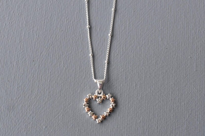 Heart of Stars heart-shaped pendant, designed with interconnecting stars and tiny cubic zirconias set in every other star. Available in all silver or silver and rose gold.