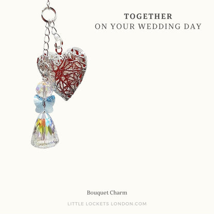A crystal angel and a filigree locket make up tis wedding bouquet charm. The angel has blue wings in a nod to the something blue traditions. Mounted on card and placed in a gift box. The card reads "Together on your wedding day"