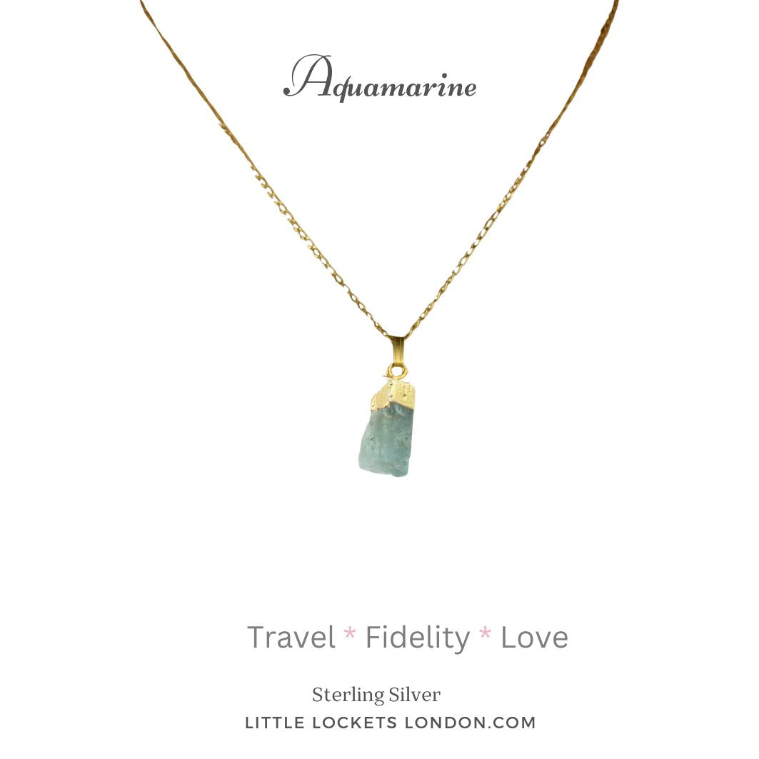 Aquamarine raw crystal with 19k gold plated sterling silver tip and chain. Mounted on card  listing three properties of the crystal - travel, fidelity, love