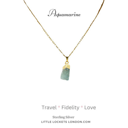 Aquamarine raw crystal with 19k gold plated sterling silver tip and chain. Mounted on card  listing three properties of the crystal - travel, fidelity, love