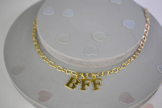 Model wears Necklace chain with and letters. Crafted with a 5.5mm link size chain in gold vermeil with serif letters spelling out  BFF (Best Friends Forever). Each letter is a classic serif uppercase font.