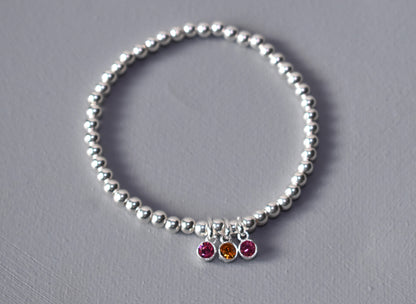 Sterling silver beaded bracelet of 4mm beads threaded onto strong elastic with three birthstones. Up to five birthstones can be added to this bracelet