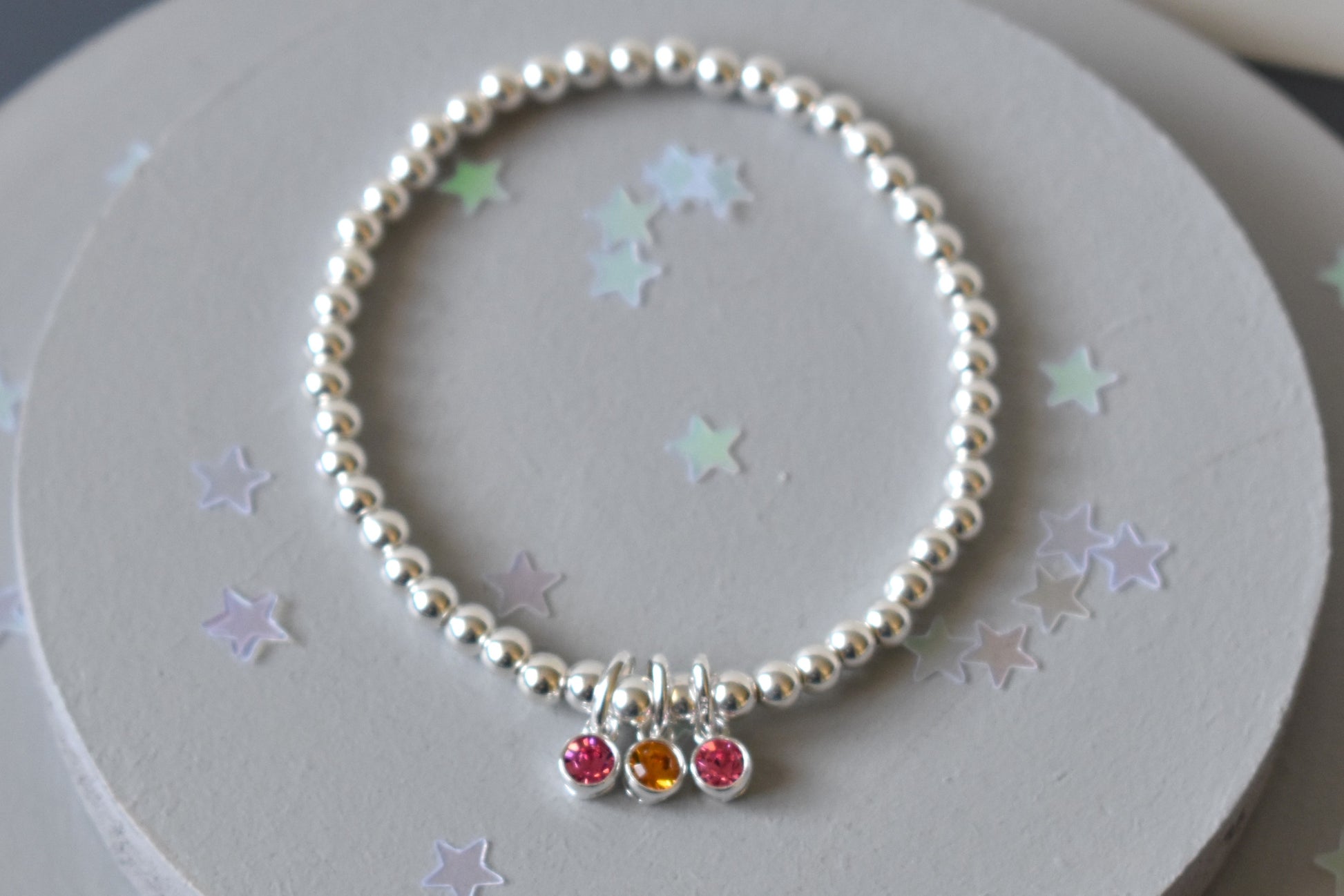 Sterling silver beaded bracelet of 4mm beads threaded onto strong elastic with three birthstones. Up to five birthstones can be added to this bracelet