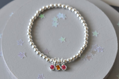 Sterling silver beaded bracelet of 4mm beads threaded onto strong elastic with three birthstones. Up to five birthstones can be added to this bracelet
