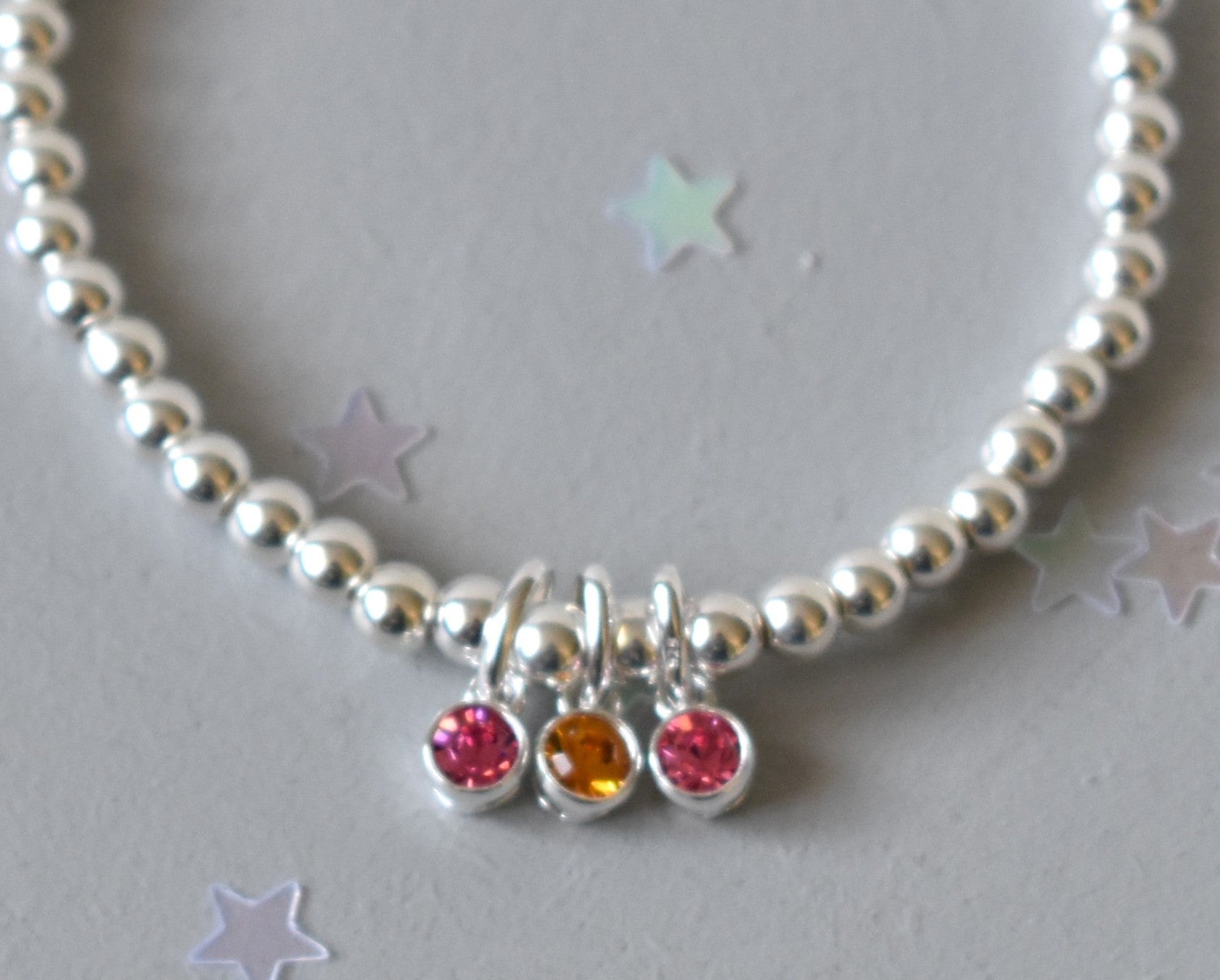 Sterling silver beaded bracelet of 4mm beads threaded onto strong elastic with three birthstones. Up to five birthstones can be added to this bracelet