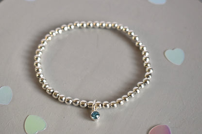 4mm sterling silver beaded bracelet threaded onto strong elastic with 10mm sterling silver birthstone charm (aquamarine)