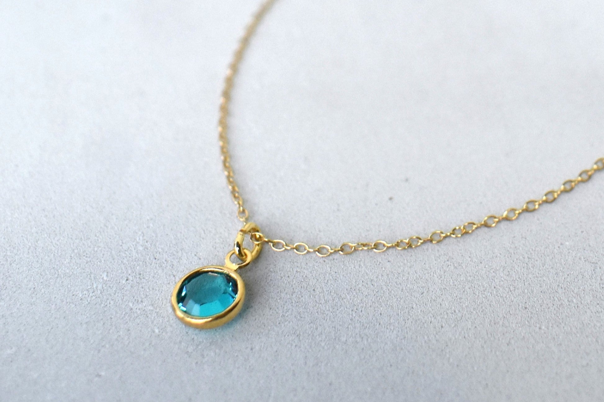 A gold filled chain is  threaded through a bead to make this delicate bracelet adjustable. Finished with a birthstone of your choice, ths bracelet is the perfect summer accessory.