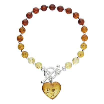 Cognac amber graduated bead bracelet  in varying and graduated tones of amber fastened with sterling silver TBar clasp and dangling heart charm. 