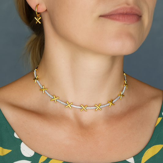 A delicate sterling silver necklace with gold plated kiss charms separated by sparkling CZ stones. Comes with small extension chain