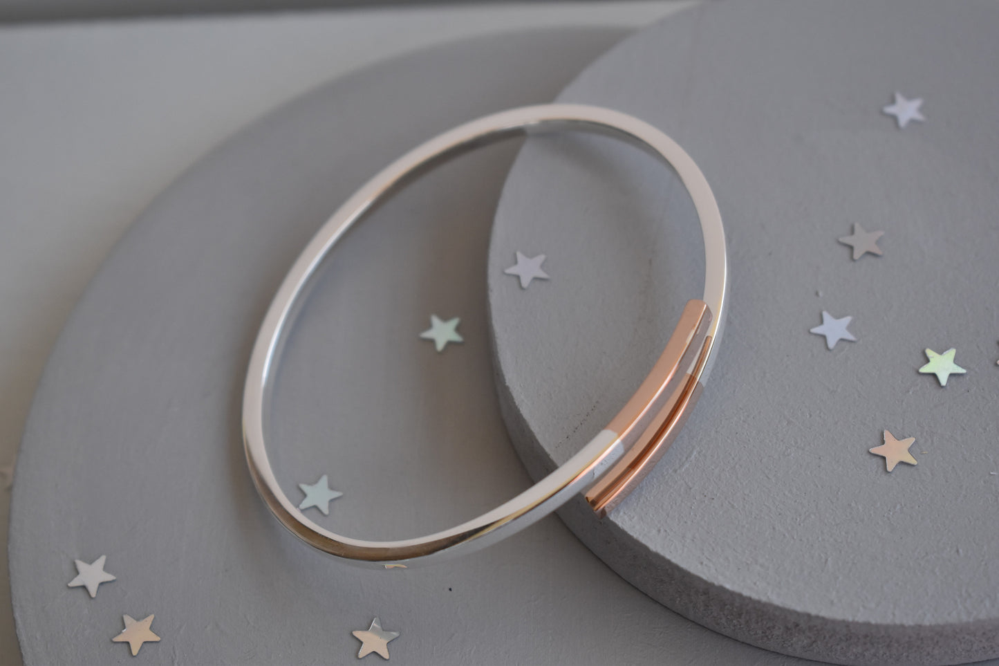 Sterling silver cross over bangle with rose gold tipped ends
