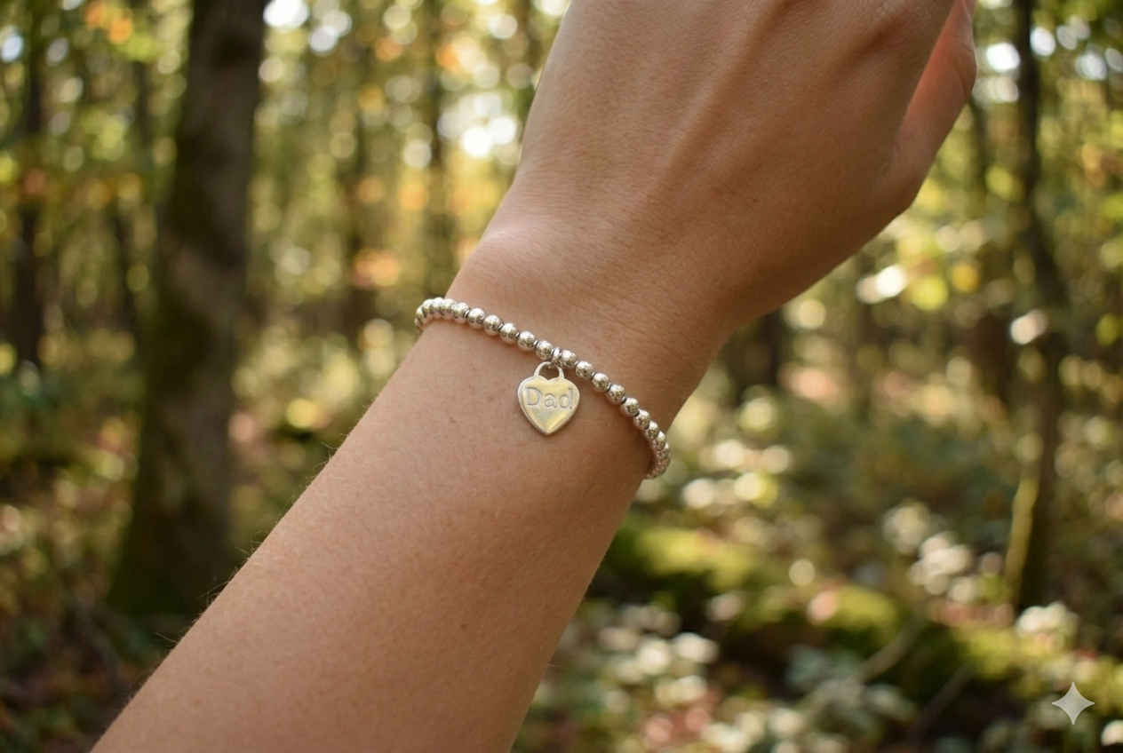 Sterling silver 4mm beaded bracelet with a 16mm sterling silver heart engraved with the word "Dad". Engraving can be words of your choice. Bracelet is threaded onto strong elastic, no fastening required.