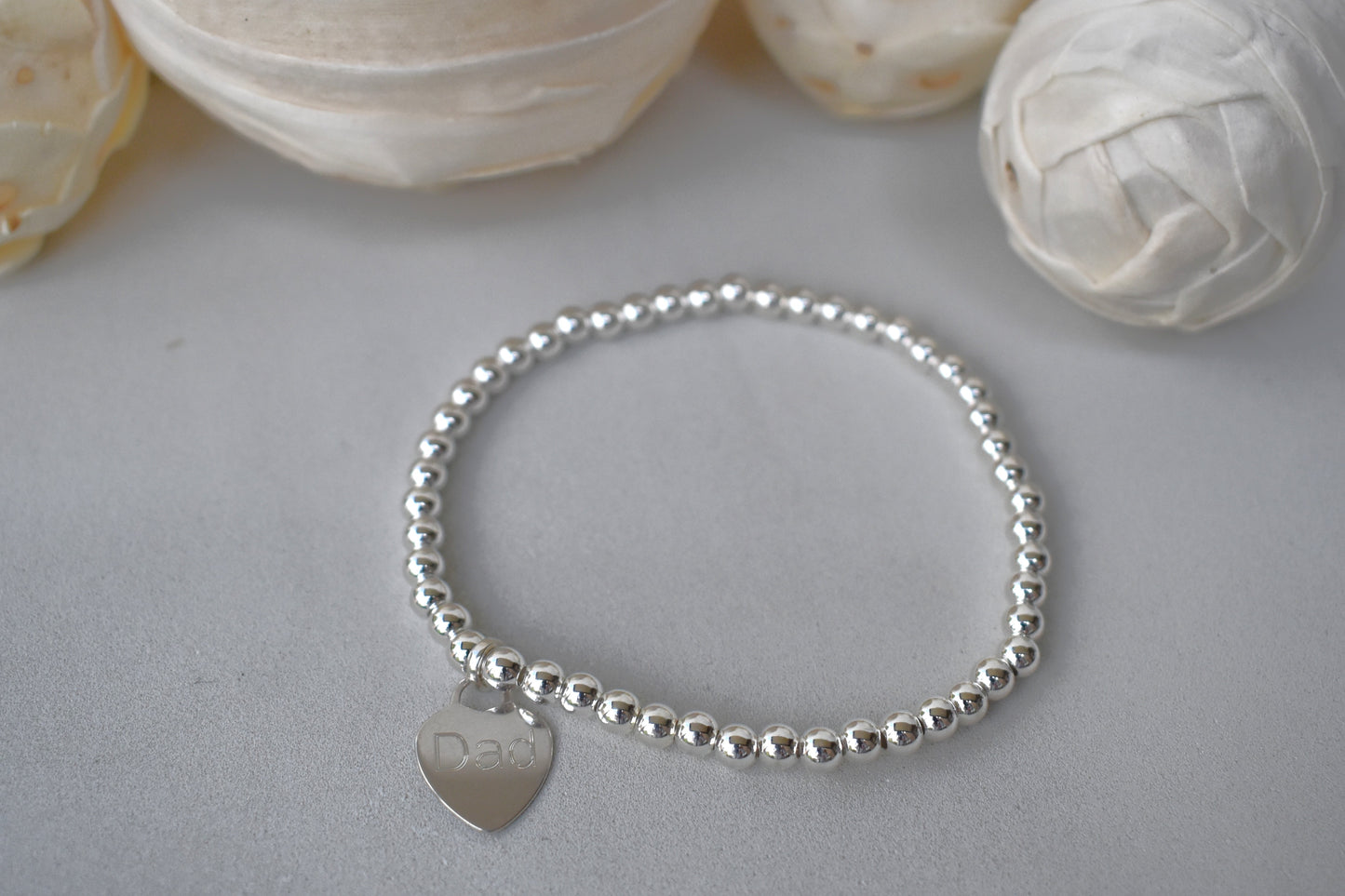 Personalised silver beaded elastic bracelet with engraved sterling silver heart charm, custom name or date, sterling silver shown