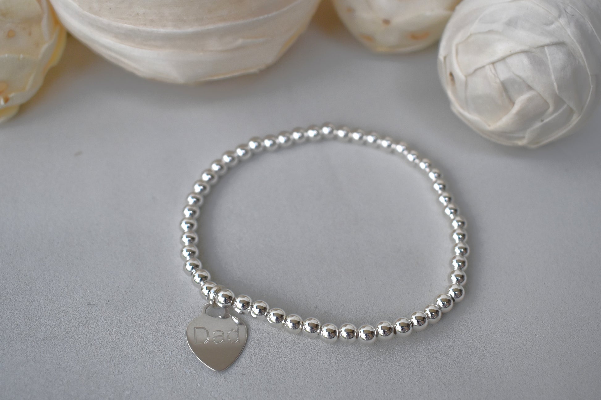 Personalised silver beaded elastic bracelet with engraved sterling silver heart charm, custom name or date, sterling silver shown