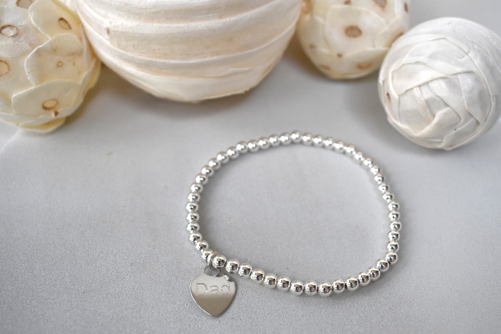 Personalised silver beaded elastic bracelet with engraved sterling silver heart charm, custom name or date, sterling silver shown