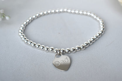 Personalised silver beaded elastic bracelet with engraved sterling silver heart charm, custom name or date, sterling silver shown