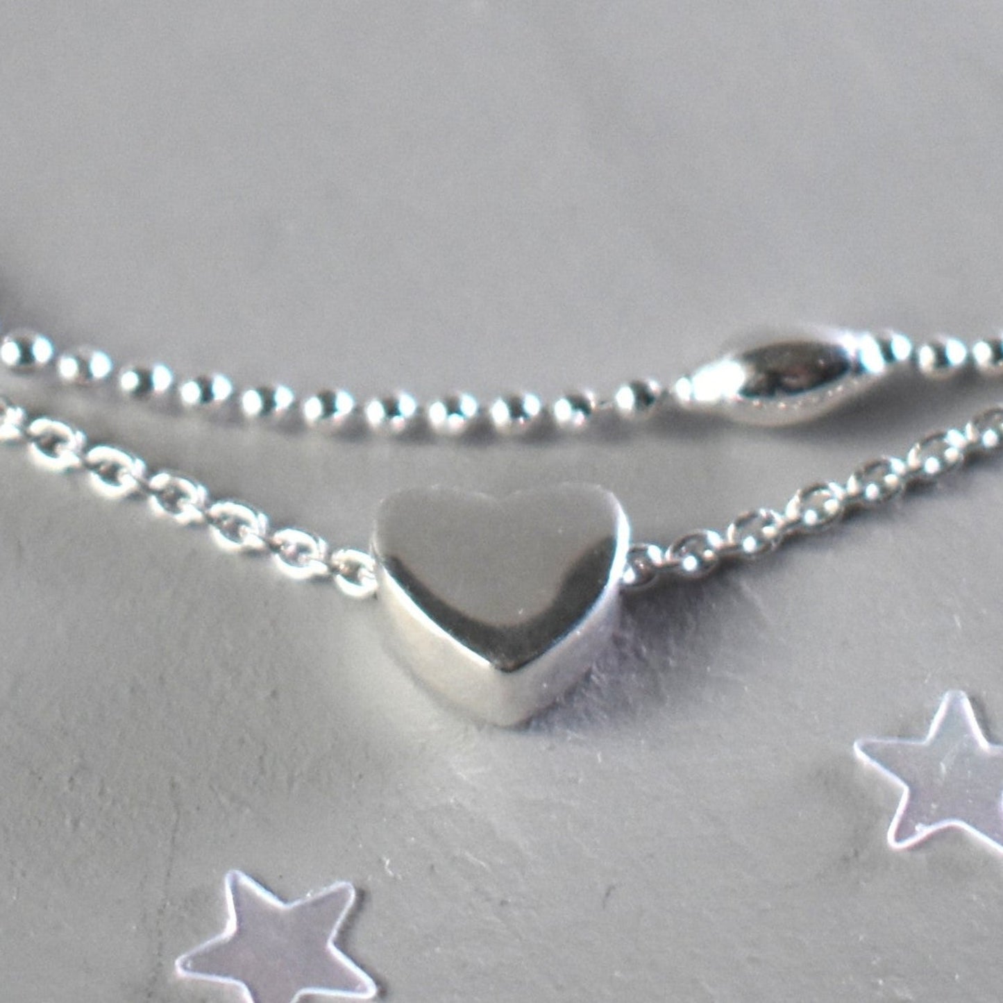 Front view of heart on sterling silver double strand anklet with a heart centre. Optional blue bead near the lobster clasp fastening. 