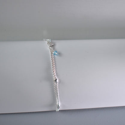 Sterling silver double strand anklet with a heart centre. Showing optional blue crystal near the lobster clasp fastening. 