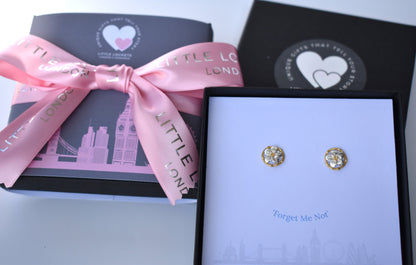 Forget me not stud earrings shown mounted on card in branded gift box. Beneath the earrings are the words "Forget Me Not". 