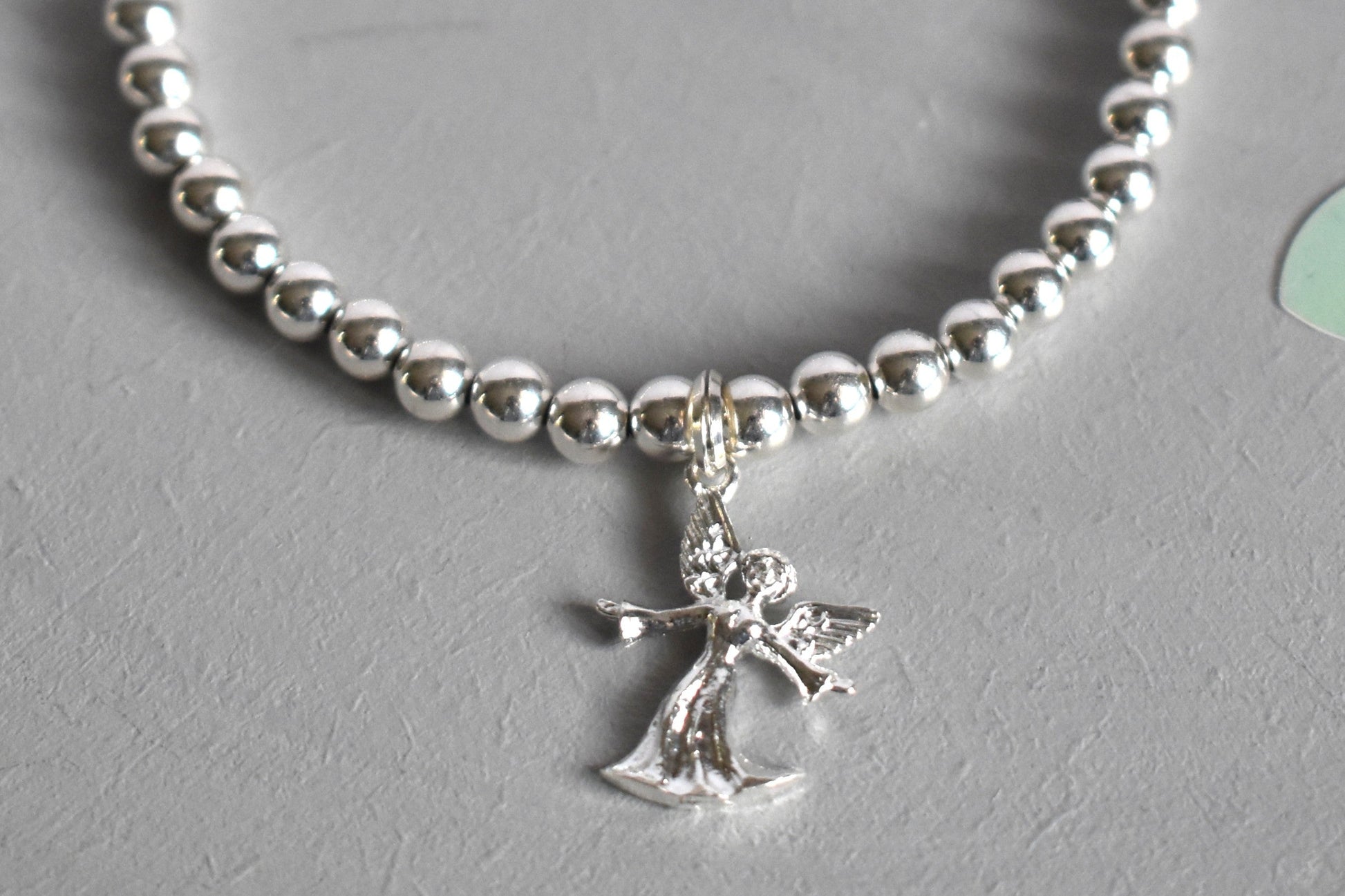 Close up of Sterling silver beaded bracelet with 4mm beads and a 16mm sterling silver angel charm