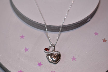 Sterling silver heart shaped locket with engraved family tree on the front. Opens to show space for two photos. Shown on an adjustable 16-18 inch sterling silver chain and with an optional birthstone.