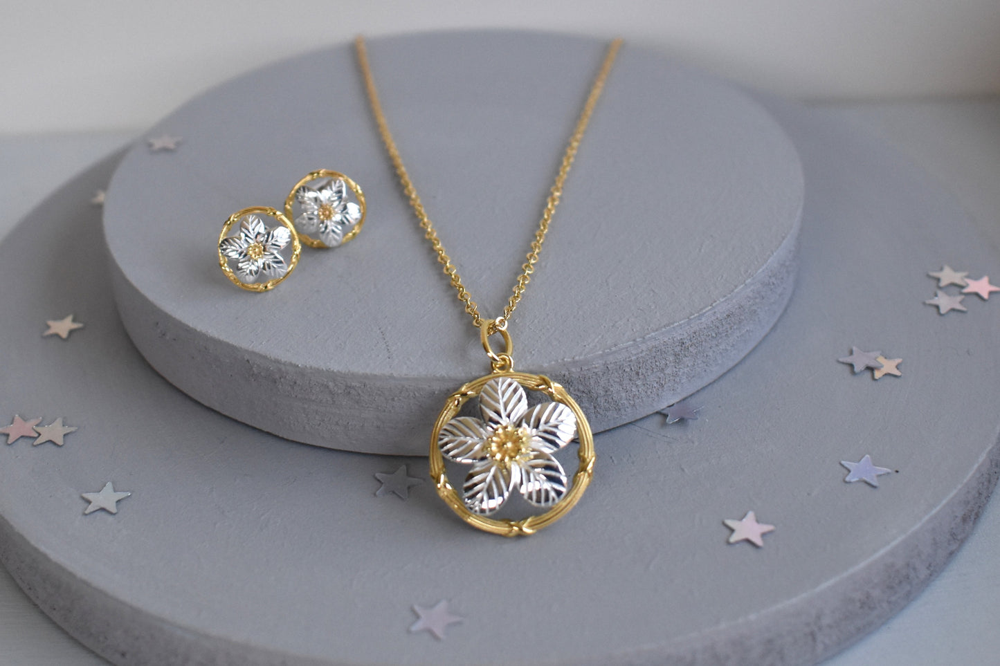 Sterling silver and gold plated forget me not pendant.  A delicate forget me not with sterling silver petals encased within a gold plated circle. Matching stud earrings.