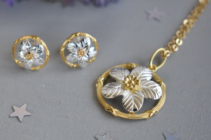 Sterling silver and gold plated forget me not pendant.  A delicate forget me not with sterling silver petals encased within a gold plated circle. Matching stud earrings.