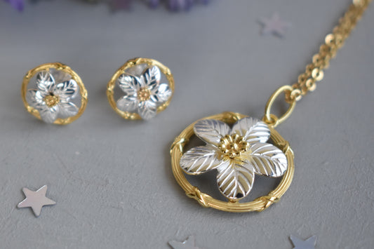 Sterling silver and gold plated forget me not pendant.  A delicate forget me not with sterling silver petals encased within a gold plated circle. Matching stud earrings.