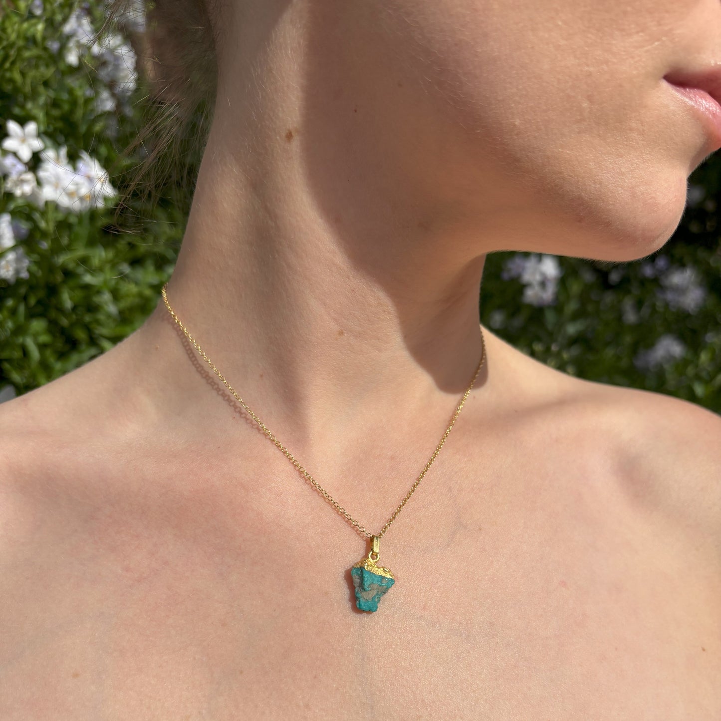 Raw Crystal Pendant. The pendant has a gold plated sterling silver tip and is suspended from a gold plated sterling silver chain. It is mounted on card with the gemstone name and three of the properties of the crystal. 