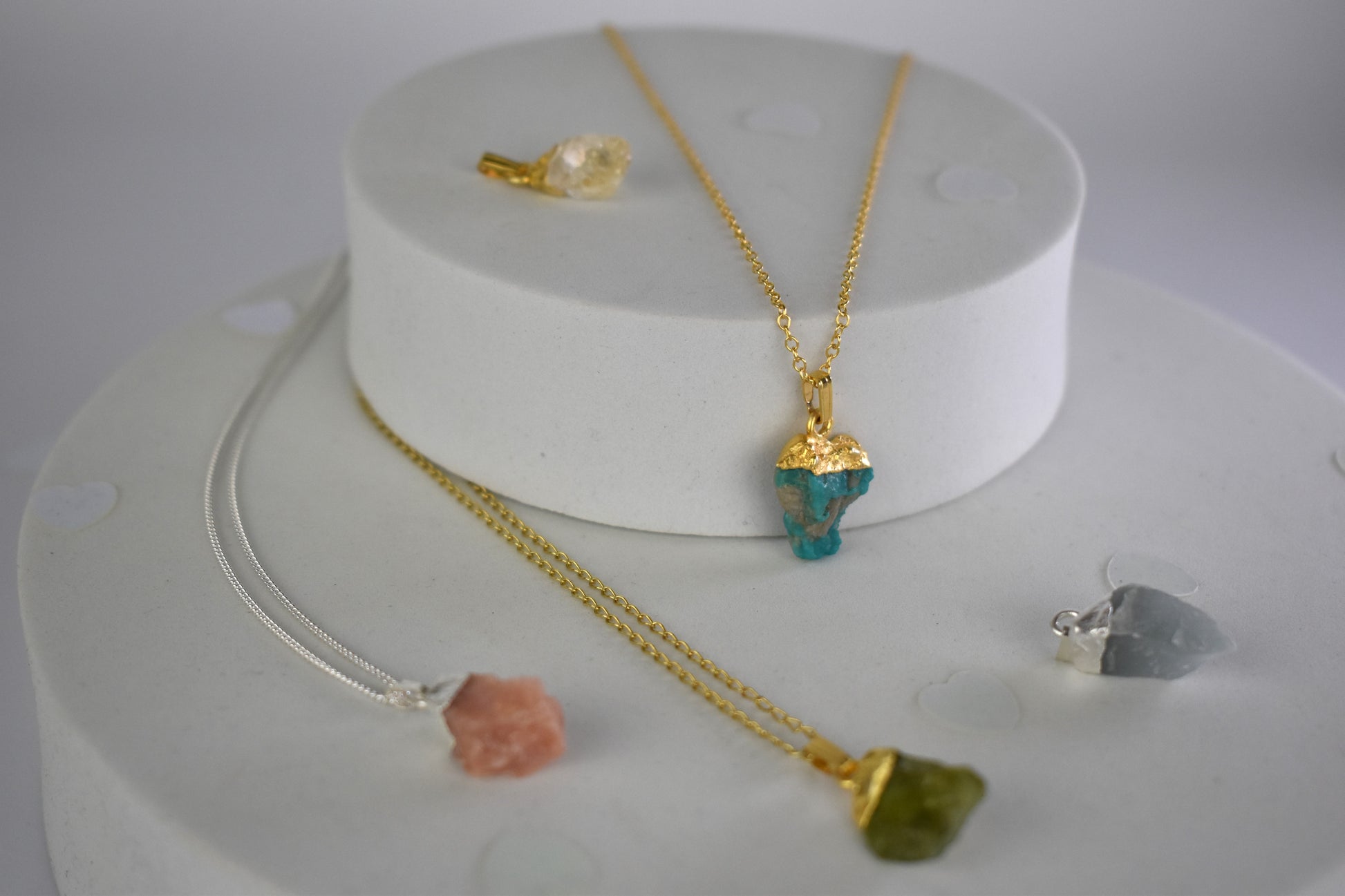 selection of raw crystal gems pink opal, citrine, turquoise, moonstone and peridot