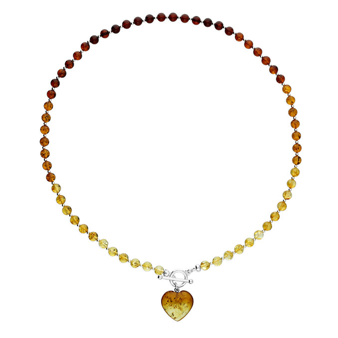 Cognac amber beads for a necklace which is fastened at the front by a sterling silver T bar. Suspended from the fastener is a cognac amber heart. 
