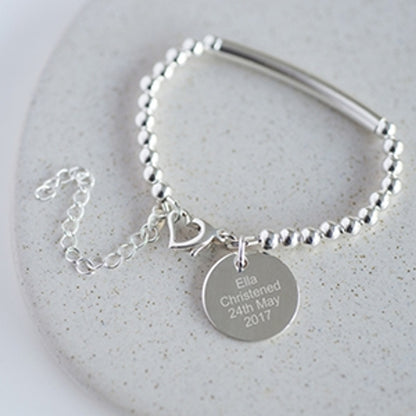 Sterling silver bead and bar christening bracelet with heart shaped lobster clasp. The attached sterling silver disc can be engraved with your own message of up to 30 characters including spaces on each side
