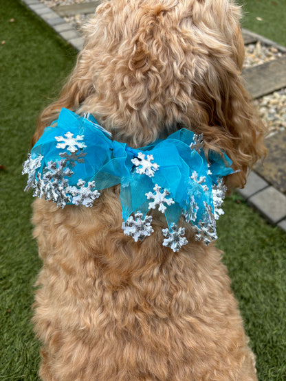 Blue tulle ribbons entwined on a comfortable elastic band frill. Each ribbon is adorned with silver snowflakes