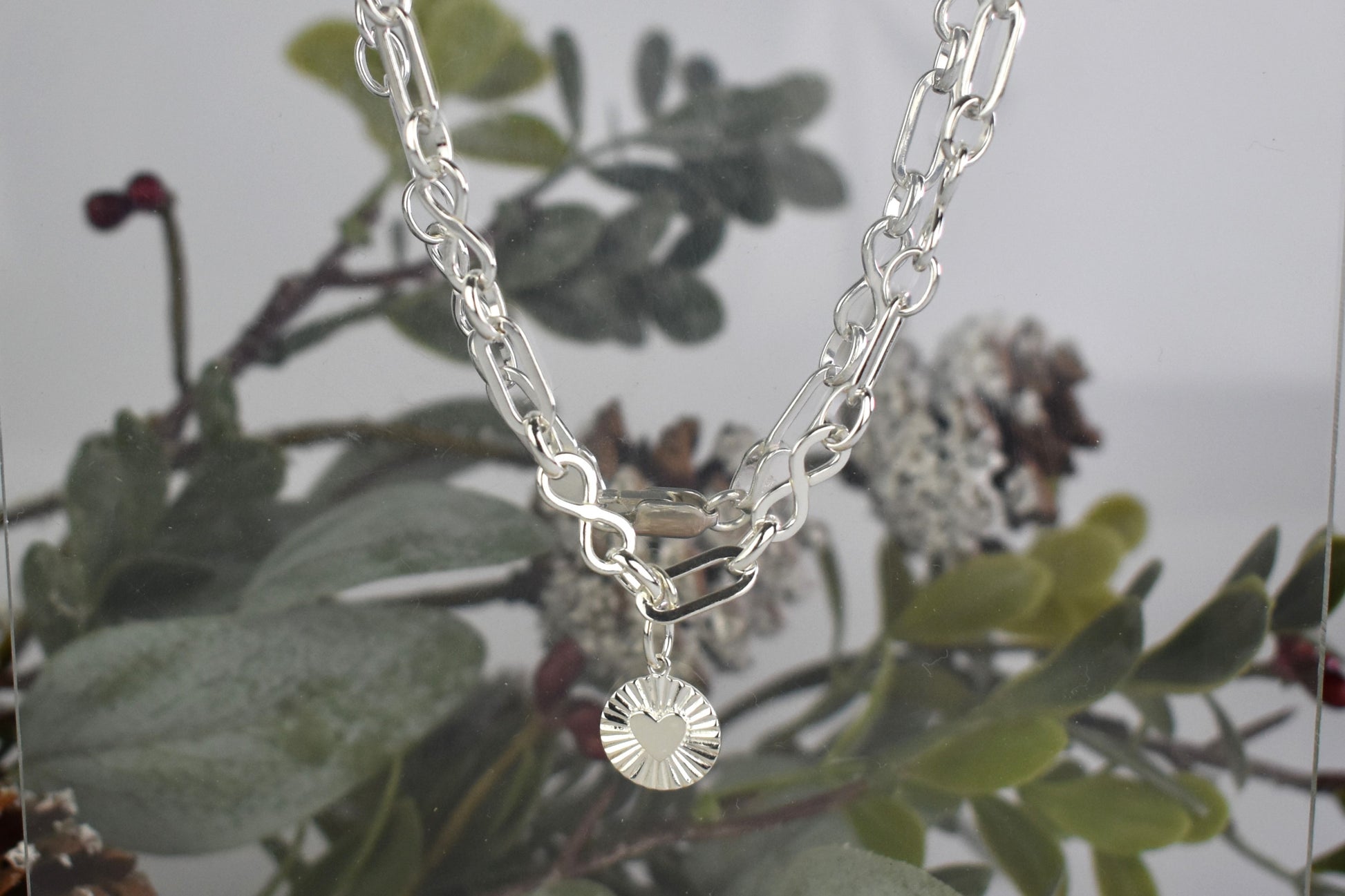 Sterling Silver Handmade Flat Link Infinity Necklace featuring a Heart Rays Pendant. Showcases flat oval and infinity links and features a Sterling Silver Sunburst Heart Rays charm pendant surrounded by an intricate sun rays design