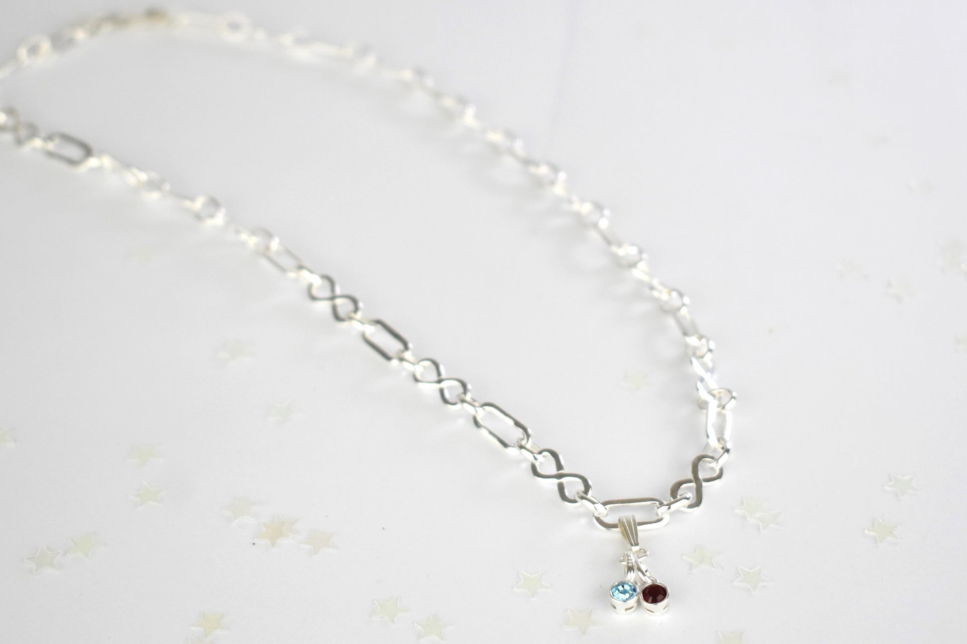 Sterling silver necklace of linked infinity symbols hung with birthstones of your choice