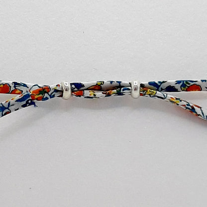 Reverse of bracelet showing fabric passing through to beads, the ends are tied in little knots.