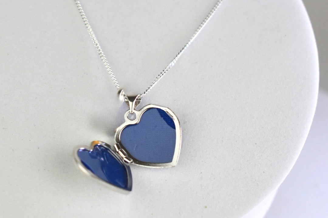 Sterling silver heart locket open to reveal photo windows