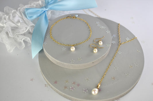 Something blue gift set shown in gold filled finish. Freshwater pearls. on a lariat necklace, chain bracelet both finished with a tiny blue crystal or pearl. Matching freshwater pearl earrings on gold plated wires. 