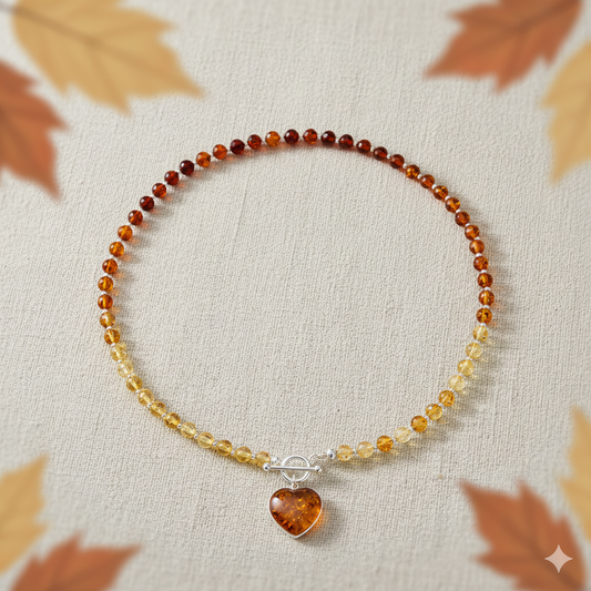 Cognac amber beads for a necklace which is fastened at the front by a sterling silver T bar. Suspended from the fastener is a cognac amber heart. 