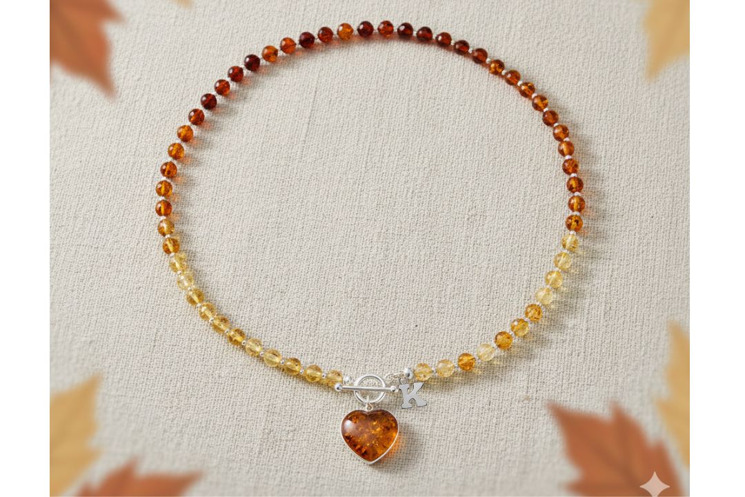 Necklace consisting of cognac amber beads with a sterling silver T bar fastening and a cognac amber heart suspended from the fastening. Shown with an added sterling silver initial

