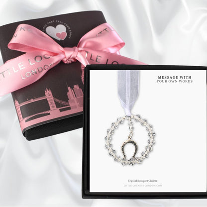 A circle of high quality crystals surround a sterling silver horseshoe charm. Suspended from white organza ribbon and placed on card with the message of your choice. Your item will be placed in a gift box with gift wrap of your choice. Shown is our upgraded gift wrap with a London skyline wrap and pink branded hand tied ribbon