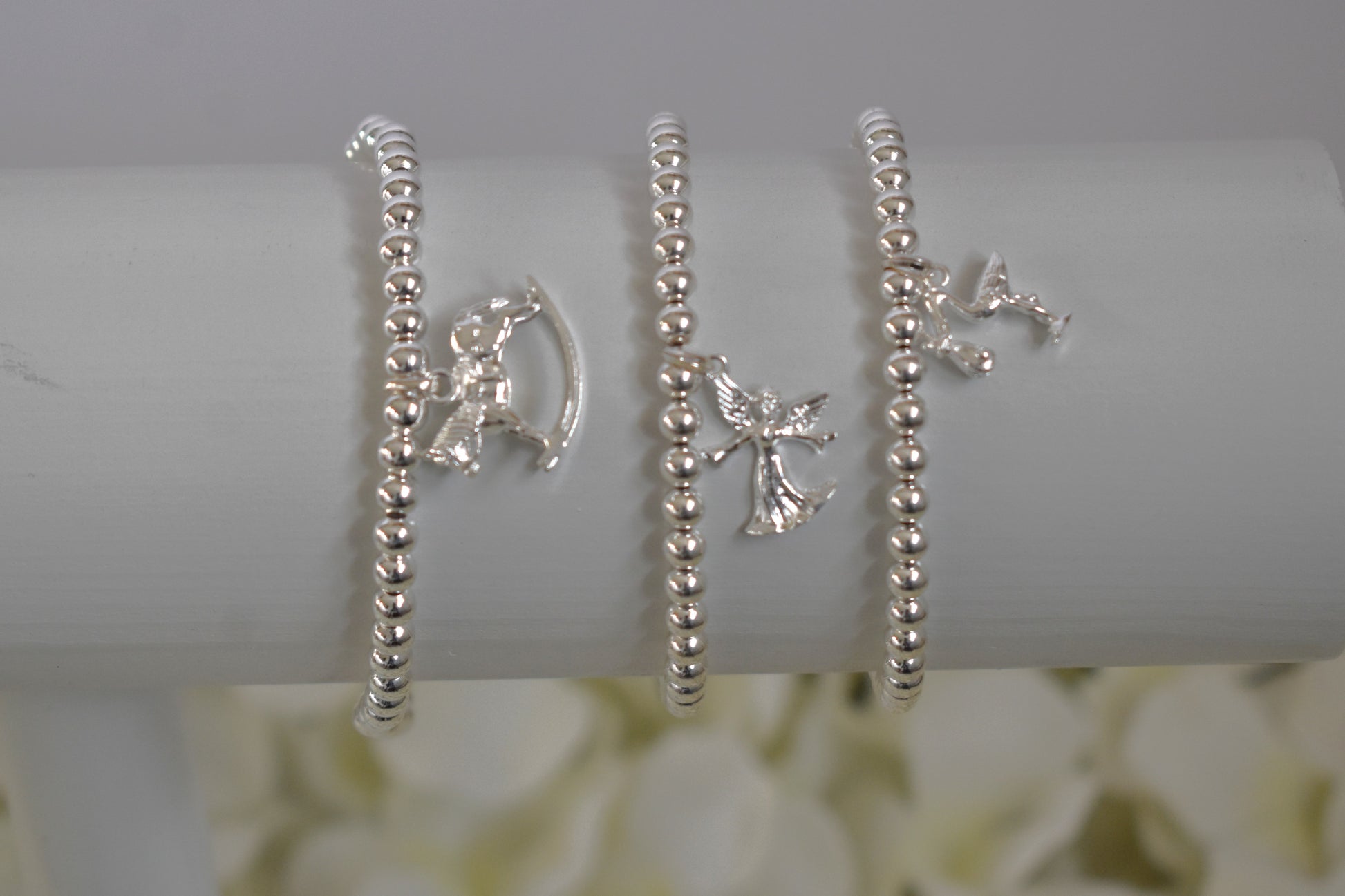 Three silver beaded bracelets - rocking horse, fairy and stork,