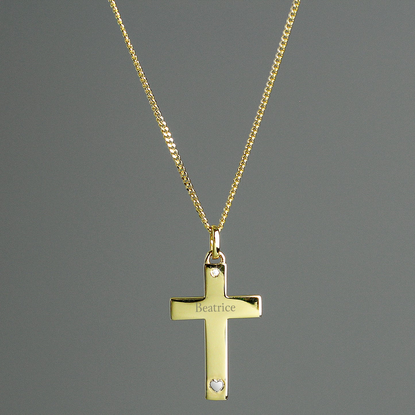 9CT gold plated sterling silver cross and chain, with a tiny zircona at the head of the cross and a small sterling silver heart at the base, the cross is suspended from an 18" gold plated chain and can be personalised with a name of your choice.