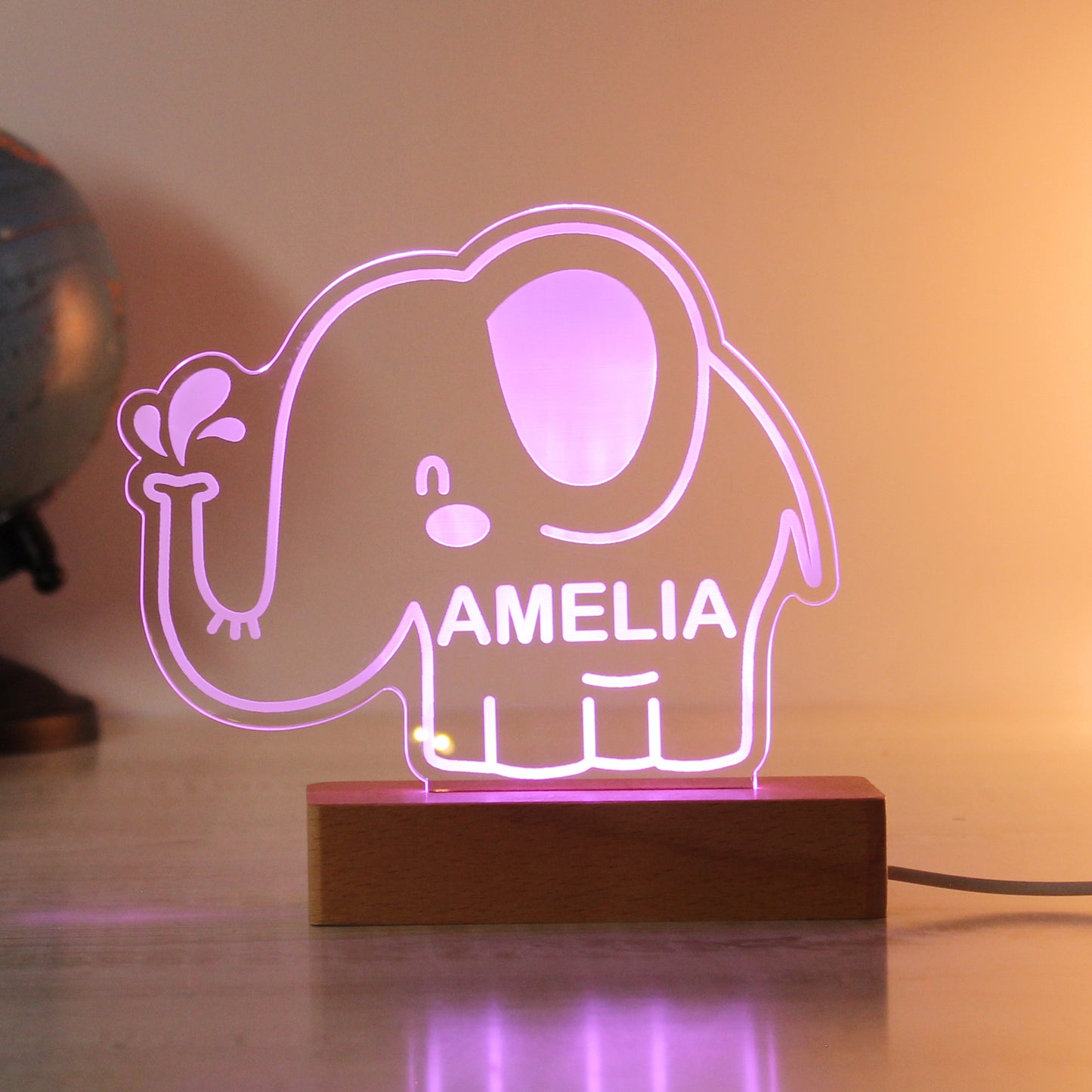 Childs LED light on wooden base. Cartoon elephant personalised with your child's name. Changing or fixed colour and brightness settings. Shown in pink