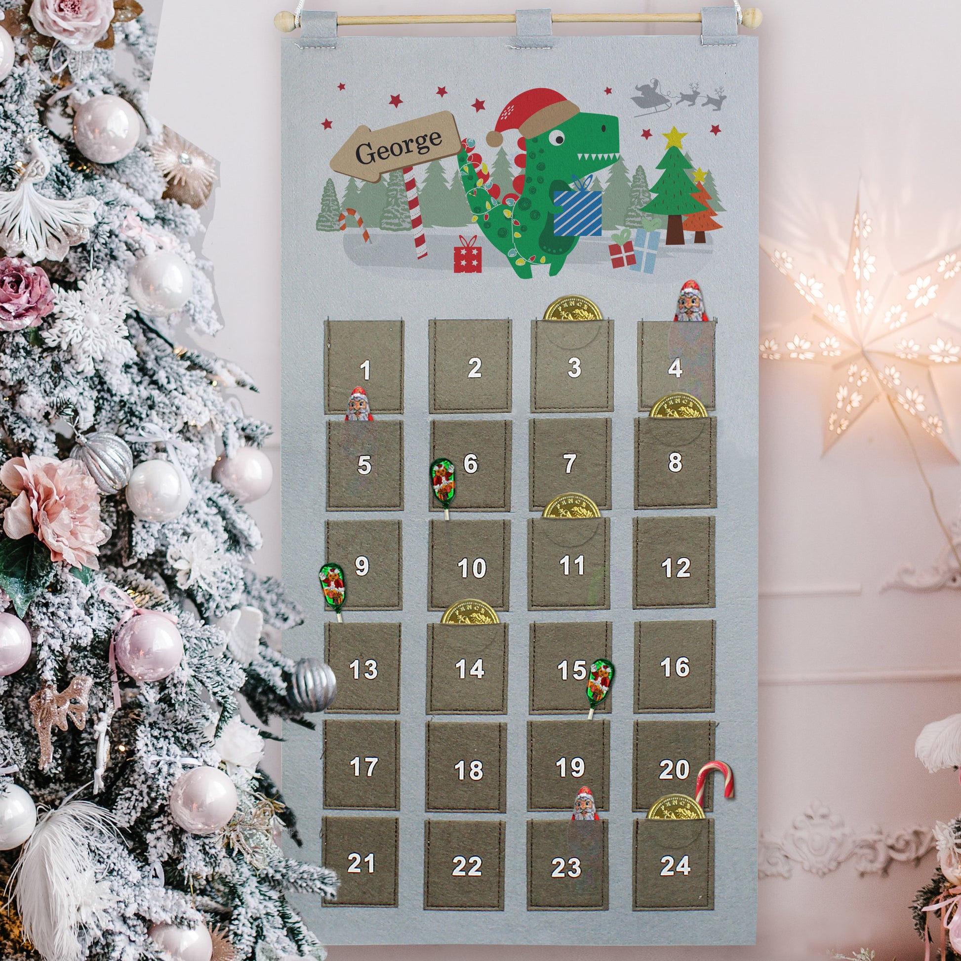 Felt advent calendar with cartoon dinosaur illustration and candy stripe sign personalised with a child's name 